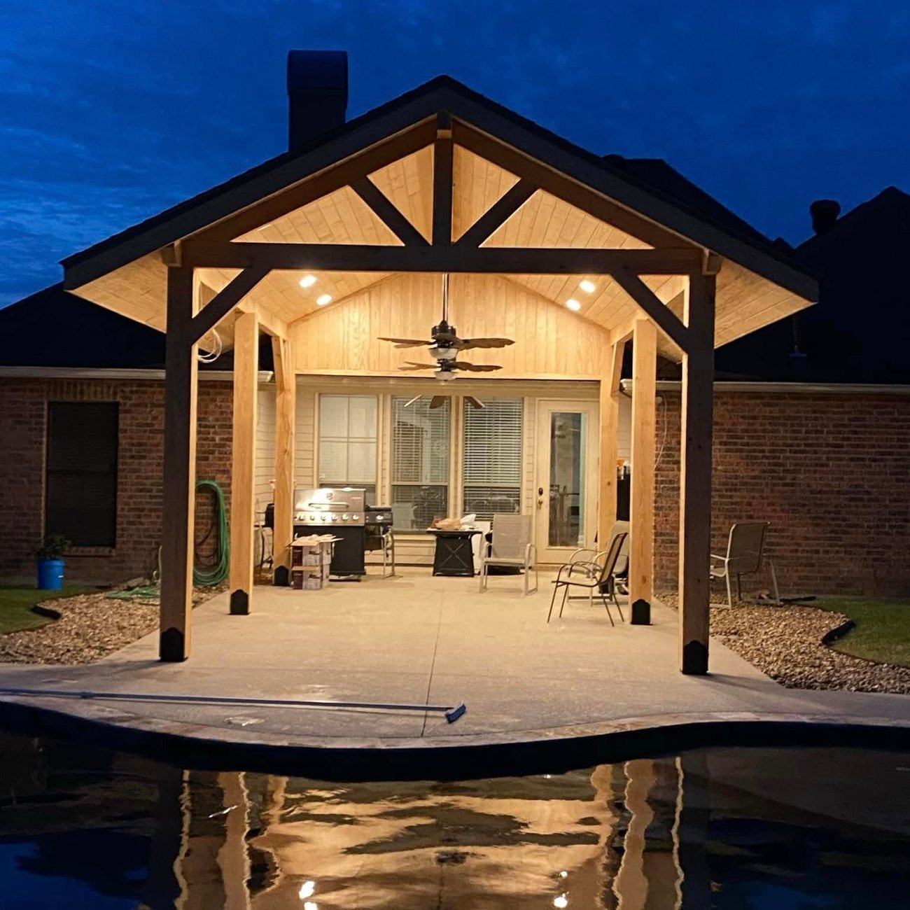 Gable roof pavilion with an exposed truss and stained tongue and groove ceiling, lit at dusk in south Louisiana