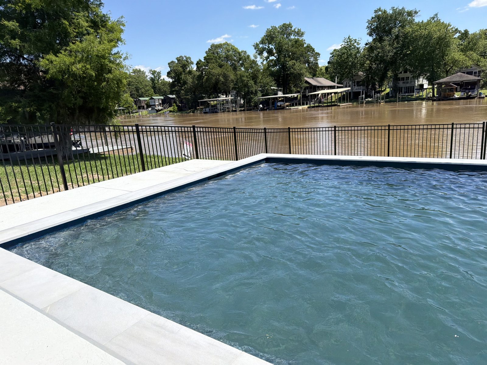 Ornamental aluminum pool fence on a waterfront lot