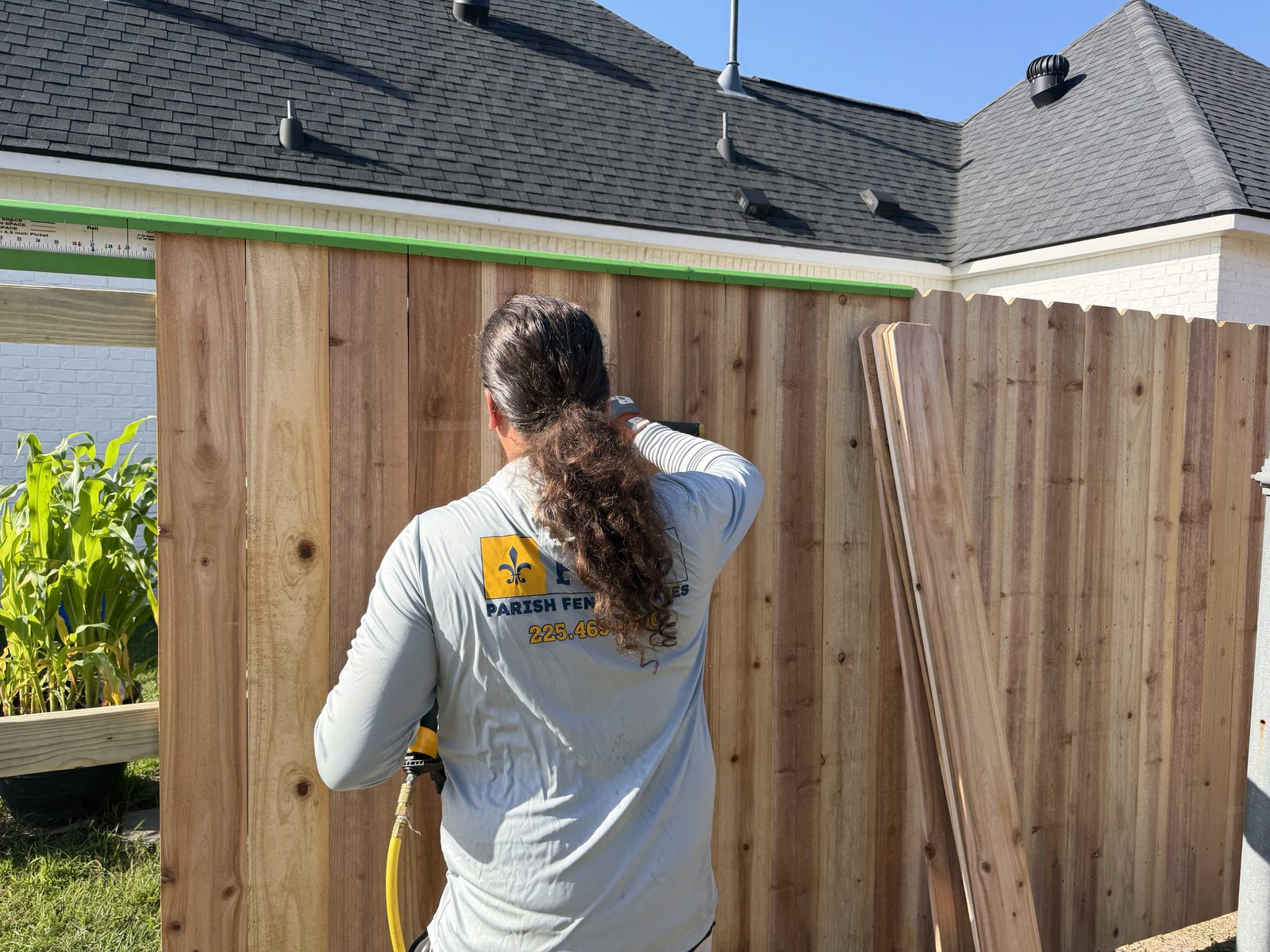 Parish crew nailing cedar pickets on a new fence